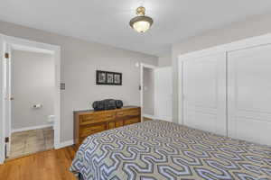 Bedroom featuring baseboards, a closet, and light wood-type flooring