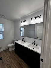 Full bathroom featuring a textured ceiling, a sink, and visible vents