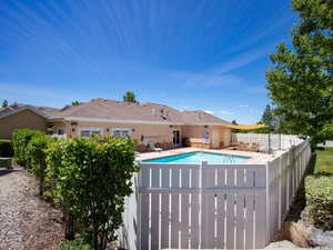 Pool with a patio and fence