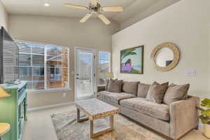 Living room with baseboards, ceiling fan, recessed lighting, lofted ceiling, and carpet floors