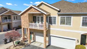 View of front of home featuring driveway, stucco siding, roof with shingles, and an attached garage