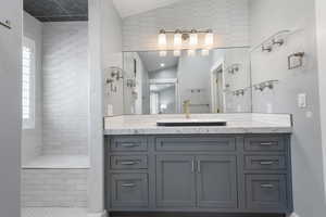 On-suite vanity with oversized shower to the left. You can see the built-in shower bench