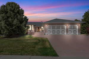 Front entrance twilight view - 3 car garage and stamped concrete driveway