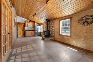 Studio living/kitchen/bath/laundry with wood burning fireplace, vaulted ceiling and radiant floors in the bathroom. French doors on left lead directly into industrial garage