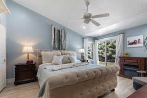 Primary bedroom alternate view featuring vaulted ceiling and looking through windows to the private backyard