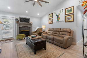 Family room with ceiling fan, gas fireplace and sliding glass doors leading to backyard