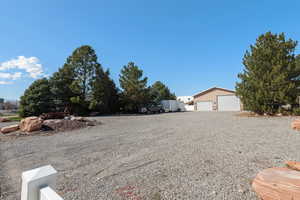 View of huge detached workshop/garage with lots of exterior parking in addition to the RV parking with full hook-ups