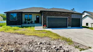 View of front of house with a garage, concrete driveway, roof with shingles, and board and batten siding