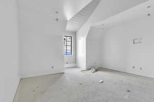 Additional living space featuring baseboards and lofted ceiling