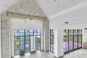 Doorway featuring high vaulted ceiling and wood finished floors