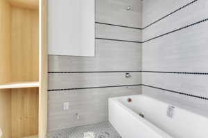 Bathroom with a garden tub, tile walls, and tile patterned flooring