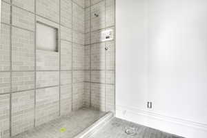 Full bath featuring a stall shower and tile patterned flooring