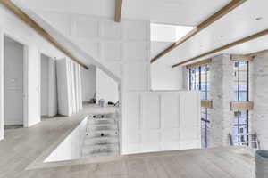 Stairs featuring beam ceiling and wood finished floors