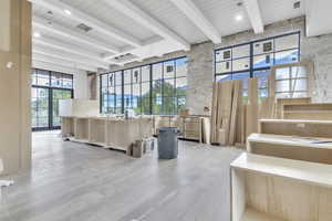 Common area featuring a wood ceiling with exposed beams and a towering ceiling