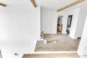 Unfurnished room featuring beamed ceiling, wood finished floors, and recessed lighting