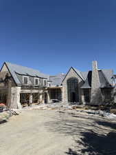 View of front facade with stone siding and a chimney