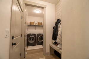 Laundry room with a textured ceiling, independent washer and dryer, laundry area, and light wood-style floors