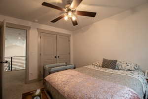 Bedroom featuring a closet, carpet floors, a textured ceiling, lofted ceiling, and ceiling fan