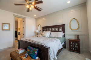 Bedroom with recessed lighting, a decorative wall, baseboards, a ceiling fan, and light carpet