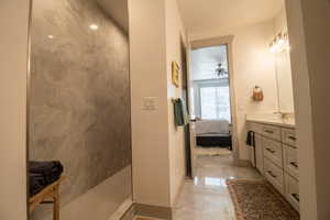 Ensuite bathroom with ensuite bathroom, vanity, baseboards, and walk in shower