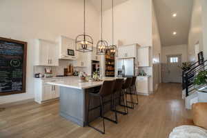 Kitchen featuring white cabinetry, light countertops, a breakfast bar area, light wood-style floors, and appliances with stainless steel finishes