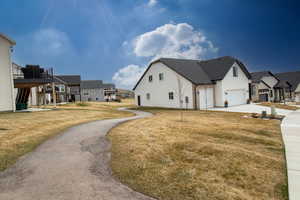 View of home's exterior with a residential view, concrete driveway, a yard, and an attached garage