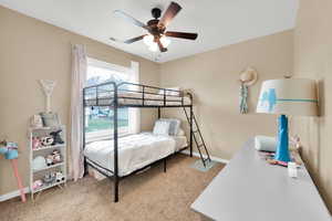 Carpeted bedroom with ceiling fan