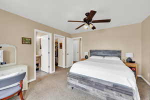 Master bedroom with carpet floors, ceiling fan, and spacious closet