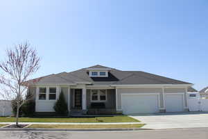 View of front of home featuring concrete driveway, a front lawn, an attached garage, fence, and a shingled roof