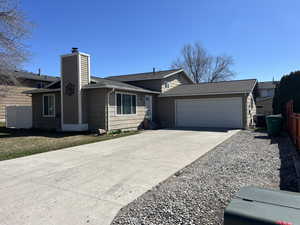 Single story home with driveway, a chimney, fence, a garage, and central AC