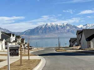 Exterior space featuring a water and mountain view, sidewalks, and curbs