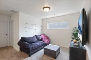 Living room with carpet floors, baseboards, and visible vents