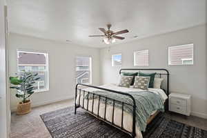 Carpeted bedroom featuring baseboards, visible vents, and ceiling fan