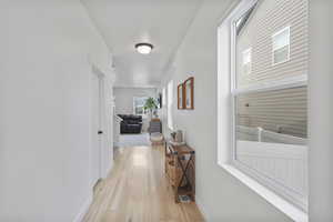 Corridor with baseboards and light wood-type flooring