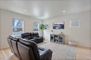 Living room featuring baseboards, wood finished floors, and recessed lighting