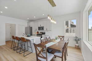 Dining area featuring baseboards, light wood-type flooring, and recessed lighting