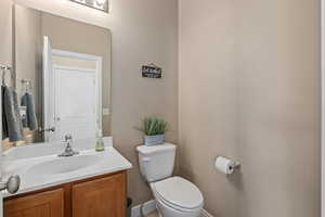 Bathroom featuring toilet, vanity, and baseboards