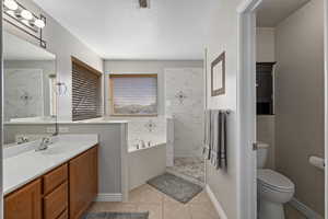 Bathroom featuring a bath, toilet, a tile shower, tile patterned floors, and vanity