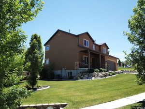 Exterior space featuring a lawn, stucco siding, and an attached garage