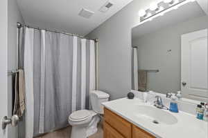 Bathroom with visible vents, tile patterned floors, toilet, and vanity