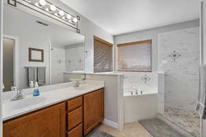 Full bath featuring double vanity, a sink, a bath, and visible vents