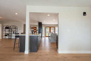 Kitchen featuring light countertops, light wood-type flooring, a kitchen breakfast bar, and baseboards
