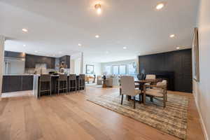 Dining room with recessed lighting, baseboards, a fireplace, and light wood-style floors