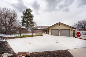 Single story home with stucco siding, an attached garage, concrete driveway, and fence
