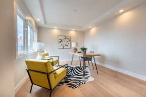 Office space with recessed lighting, a raised ceiling, wood finished floors, and baseboards
