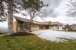 Back of house with brick siding, a yard, and a shingled roof