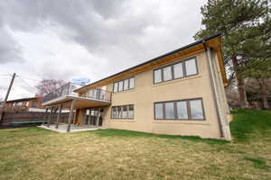 Rear view of property with stucco siding, a yard, fence, and a patio area