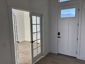 Entryway with baseboards and wood finished floors