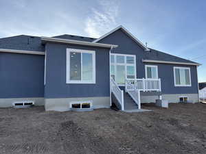 Rear view of property featuring stucco siding and roof with shingles
