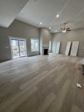 Unfurnished living room/dinning featuring a fireplace, wood finished floors, ceiling fan, and recessed lighting